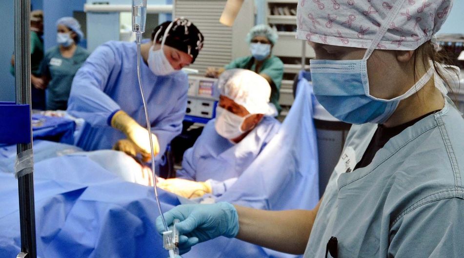 Operation Mehrere Personen in OP-Kleidung, die gemeinsam an einem Patienten arbeiten.