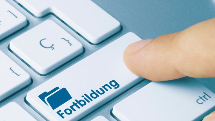 Finger drückt eine Taste auf der Tastatur mit der Aufschrift „Fortbildung“. Finger drückt eine Taste auf der Tastatur mit der Aufschrift „Fortbildung“.
